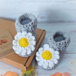 A pair of newborn crochet baby bootees crochet in silver with daisy appliques securely attached to the front. These are made and ready to be posted