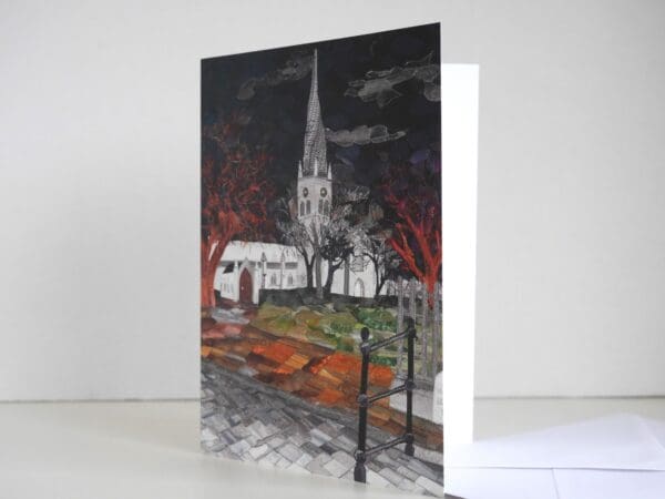 Greetings card showing textile art picture of Chesterfields crooked spire in the winter at night, with white envelope