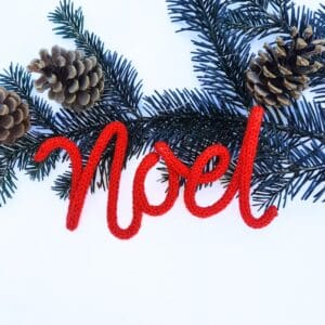 Knitted wire Christmas decoration with the word 'Noel'