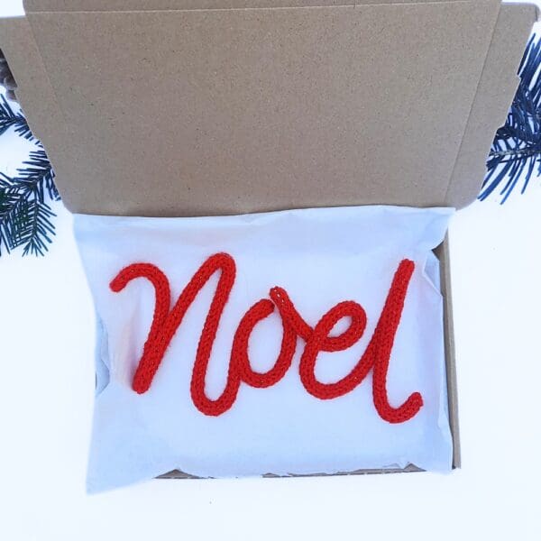 Knitted wire Christmas decoration with the word 'Noel'