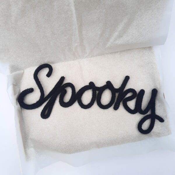 Knitted wire Halloween decoration with the word 'Spooky'