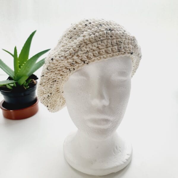 Crochet winter beret made by Sarah Lou Crafts using eco yarn made from recycled plastic bottles in a cream colour with black fleck throughout.