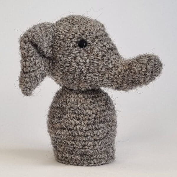 a side angle of a crocheted grey elephant