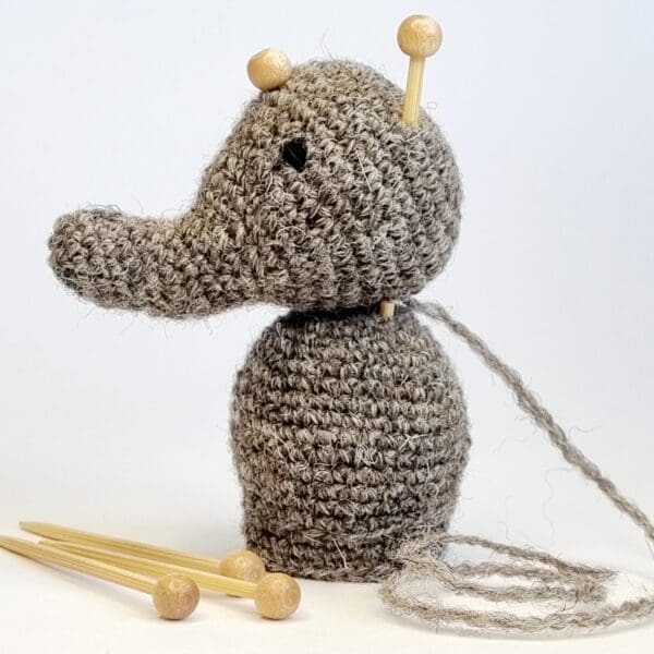 a crochet elephant with bamboo marking pins keeping head in place