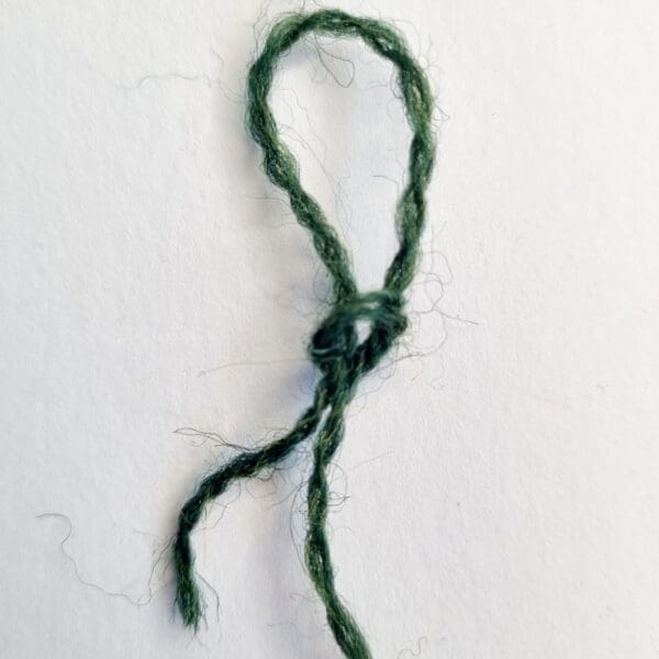 a slip knot in bottle green pure British 4ply wool