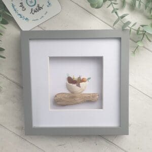 Mounted and framed picture of a bowl of fruit using genuine beach treasure of driftwood, seaglass, shell and broken clam shell.