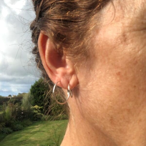 1cm and 2cm Silver Hammered Mini Hoop Earrings handmade from recycled silver. Complete round hoops. Side view of me wearing both the 1cm and 2cm hoops.