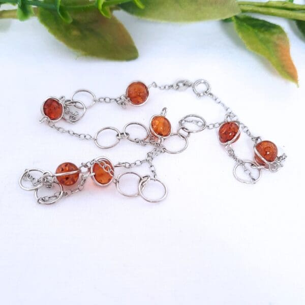 Sterling silver necklace with large circular links and amber beads in a Halo fitting.