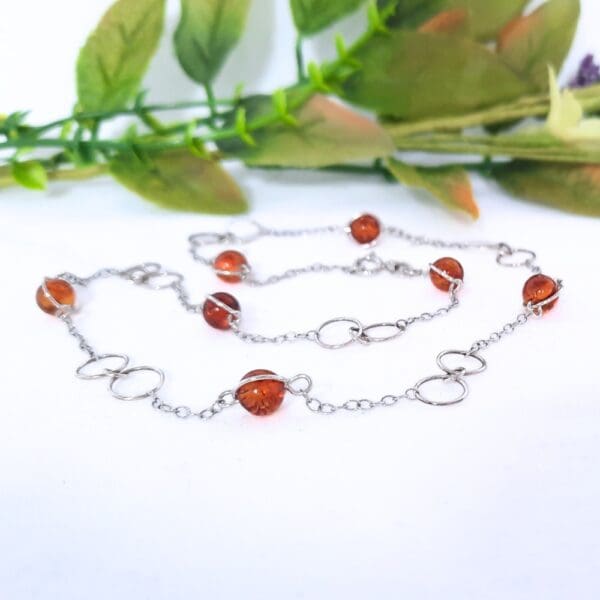 Sterling silver necklace with large circular links and amber beads in a Halo fitting.