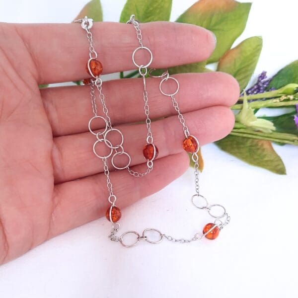 Sterling silver necklace with large circular links and amber beads in a Halo fitting.