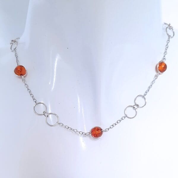 Sterling silver necklace with large circular links and amber beads in a Halo fitting.