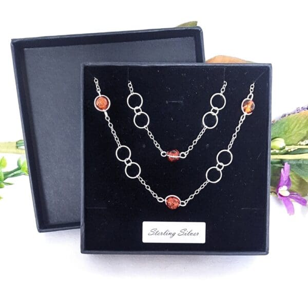 Sterling silver necklace with large circular links and amber beads in a Halo fitting.