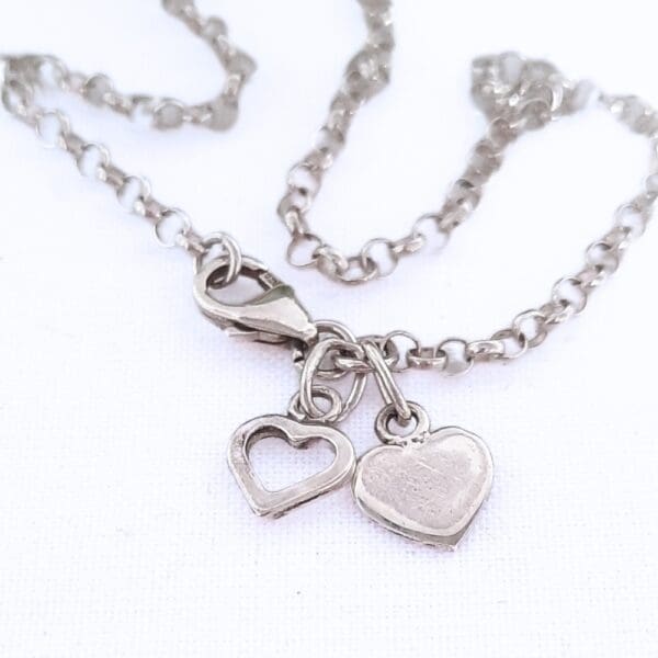 Sterling silver belcher chain bracelet with two heart charms.