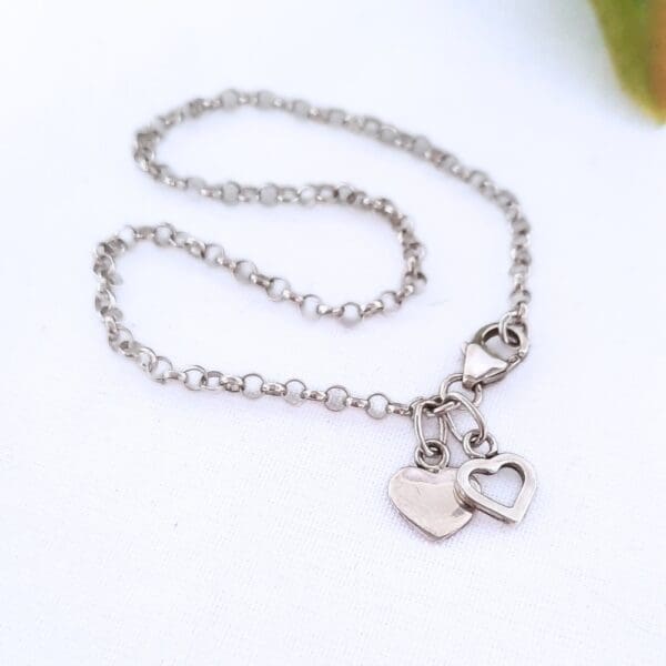 Sterling silver belcher chain bracelet with two heart charms.