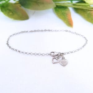 Sterling silver belcher chain bracelet with two heart charms.