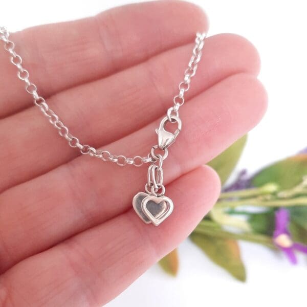 Sterling silver belcher chain bracelet with two heart charms.