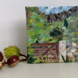 Front view of textile art collage shown with horse chestnuts as props for scale.