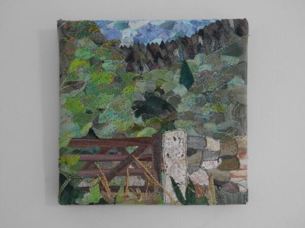 Fabric collage on canvas board showing old wooden gate beside dry stone wall, with plants in front and woodland in background.