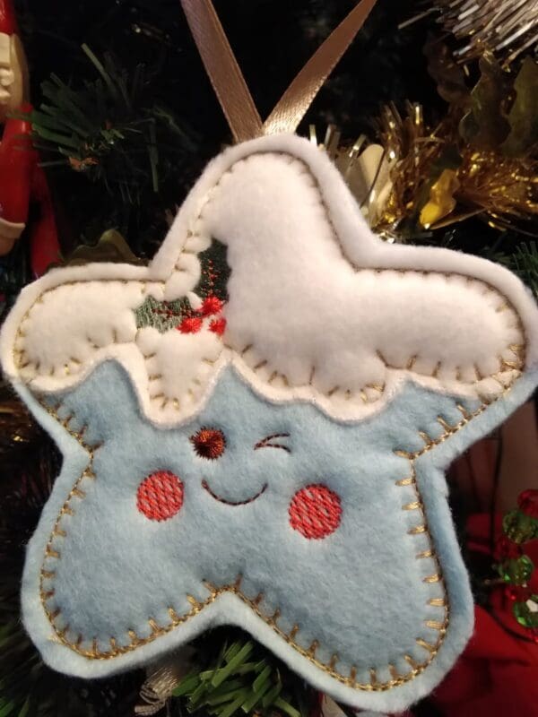 Pale blue felt star with cheeky expression in a festive Christmas theme