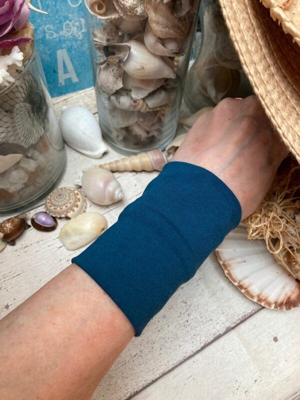 Teal cuff modelled against a white background