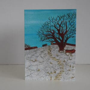 Greetings card of tree in winter on snowy hillside