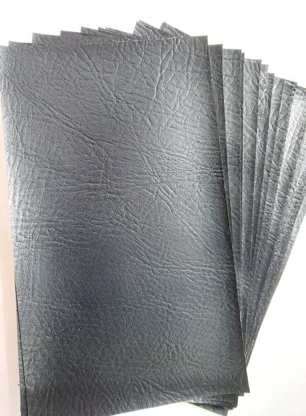 Black faux leather pieces, pre cut rectangles shown in a fanned pile on a white table.