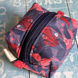 Navy and dark red pouch in box shape displayed against a sky blue background