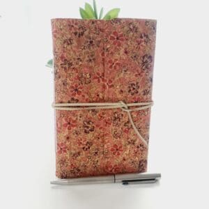 Cork fabric notebook journal with pink floral pattern and cream faux suede wrap tie, made by Sarah Lou Crafts.