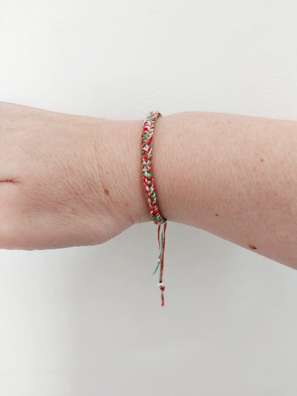 Welsh bracelet shown on raised wrist to show dangling bead detail by Sarah Lou Crafts.