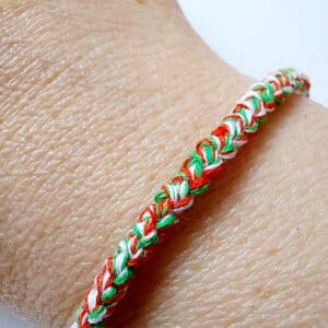 Crochet cotton cord bracelet by Sarah Lou Crafts in Welsh colours of Red, Green and White twisted threads. Shown modelled on makers wrist.