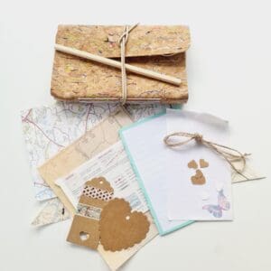 Junk Journal Starter Kit by Sarah Lou Crafts. Photo shows a Rainbow Notebook, Pencil, Map Scraps, Gift Tags, Washi Tape & String that make up the kit.