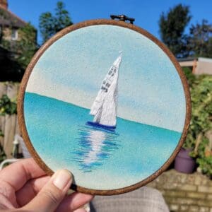 Hand embroidered sailing boat on a watercolour background 6 inch hoop.