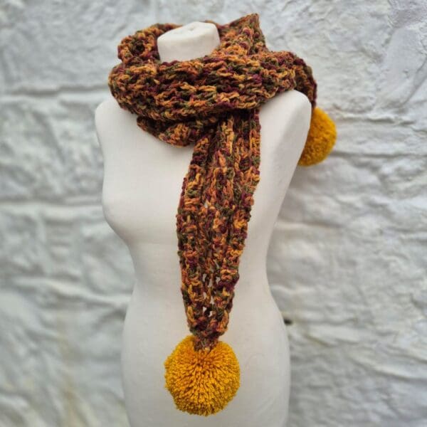 crocheted scarf with over sized pom pom