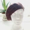 Detailed view of the grape crochet beret's brim. The edge shows a neat, finished crochet stitch, highlighting the craftsmanship from Sarah Lou Crafts. The texture of the yarn is prominent.