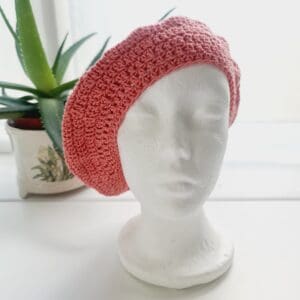 Detailed view of the pink cotton crochet beret's brim. The edge shows a neat, finished crochet stitch, highlighting the craftsmanship from Sarah Lou Crafts. The texture of the yarn is prominent.