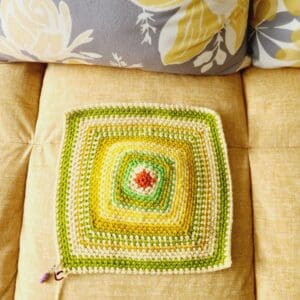 Crochet square with different coloured rows in red, yellow and green to show the top temperature taken at 12 pm each day in Carmarthenshire, Wales. 