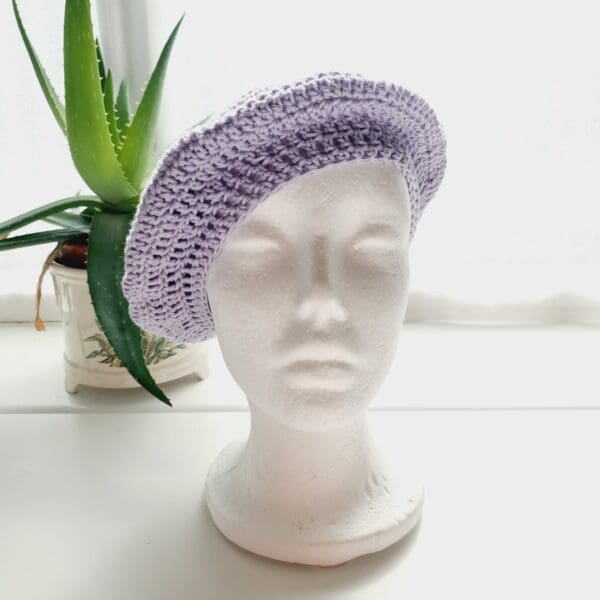 Detailed view of the lilac cotton crochet beret. The edge shows a neat, finished crochet stitch, highlighting the craftsmanship from Sarah Lou Crafts. The texture of the yarn is prominent.