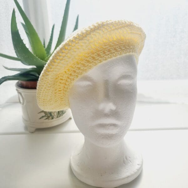 Detailed view of the yellow cotton crochet beret. The edge shows a neat, finished crochet stitch, highlighting the craftsmanship from Sarah Lou Crafts. The texture of the yarn is prominent.