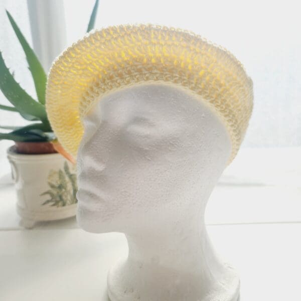 Side view of the yellow coloured crochet beret hat by Sarah Lou crafts, emphasizing the hat's slouchy, relaxed shape is apparent.