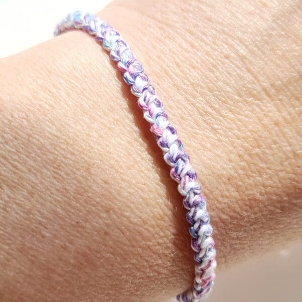 Trans bracelet shown on raised wrist to show intricate stitch detail by Sarah Lou Crafts.