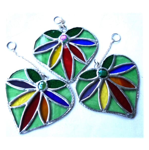 Rainbow Flower in a stained glass heart suncatcher with green surround handmade