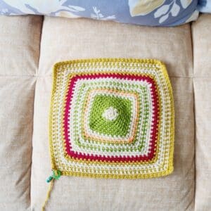 Crochet square with different coloured rows in red, yellow and green to show the top temperature taken at 12 pm each day in Carmarthenshire, Wales.