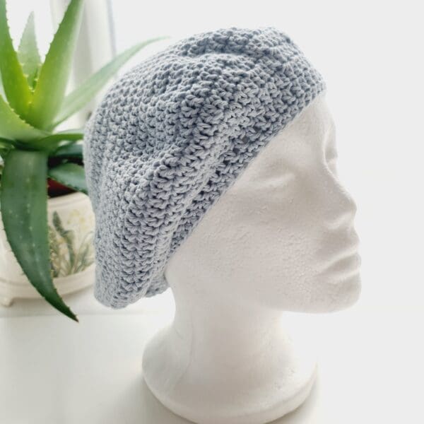Soft pastel blue crochet beret hat, made by Sarah Lou Crafts, ideal for adding a pop of colour to any outfit.