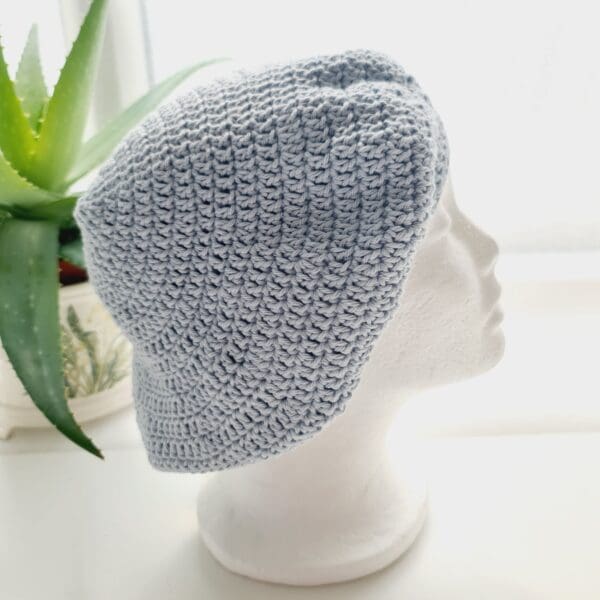 Close-up of a pastel blue crochet beret hat, highlighting its intricate stitch pattern and soft texture. Made by Sarah Lou Crafts.
