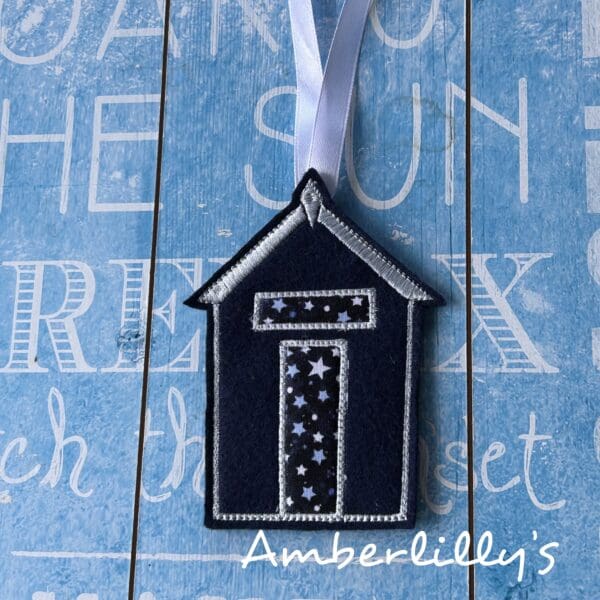Dark blue felt beach hut embroidery with star fabric and white ribbon for hanging. Approximately 10cm by 6 cm