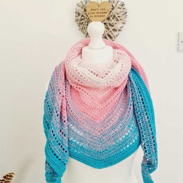 Crochet triangle scarf, handmade by Sarah Lou Crafts in Transgender Pride colours of light blue, pink, and white, shown as a comfy neck warmer, detailing the striped design.