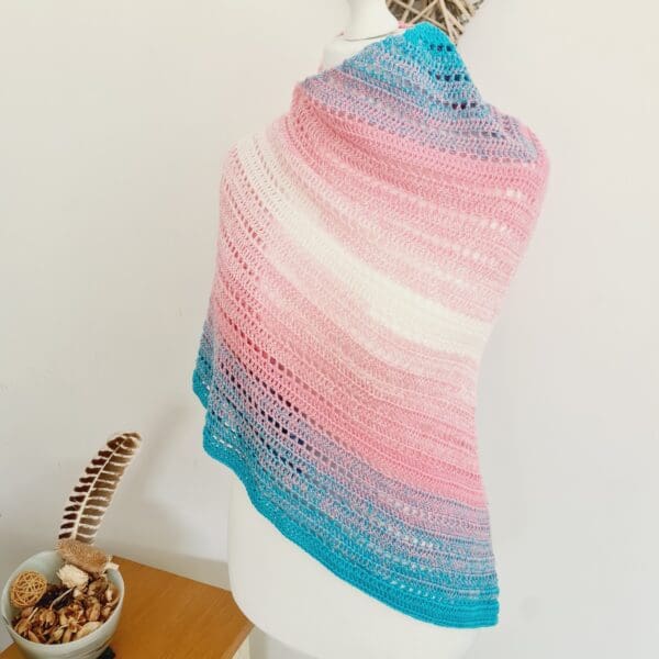 Close-up of a handcrafted crochet triangle scarf by Sarah Lou Crafts, featuring the distinctive light blue, pink, and white colours of the Transgender Pride flag.