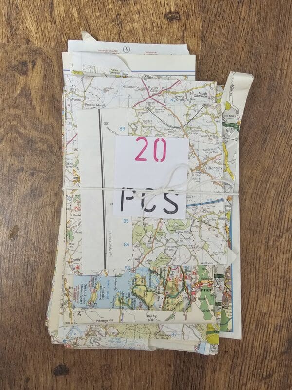 A pile of assorted map scraps, including some with intricate topographical lines and others with bright, modern city grids.