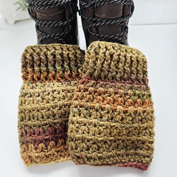 A close-up shot of the top of a brown hiking boot, showing a ribbed, dark brown crochet boot cuff with a visible seam.