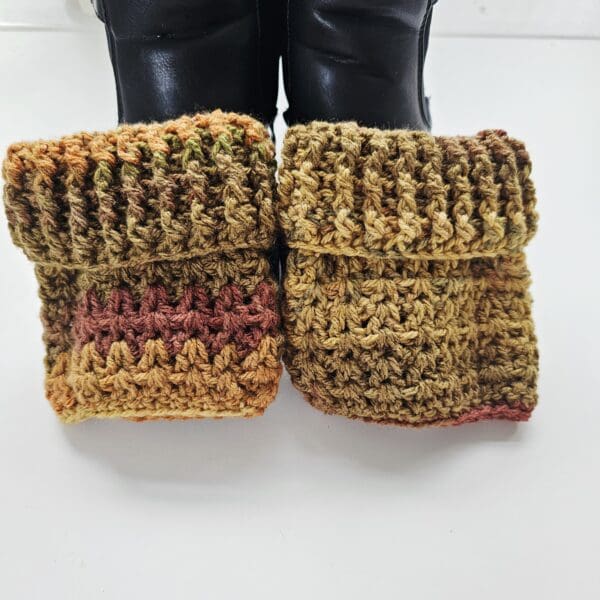 A close-up shot of the Autumn Aran boot cuffs highlighting the ribbed design shown laying on a pair of black ankle boots.